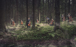 Kuopion kaupunginorkesterin soittajia soittamassa Puijon metsässä maastopyöräilijän ohittaessa heidät.